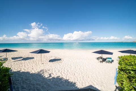 On the beach, white sand, sun loungers, beach umbrellas