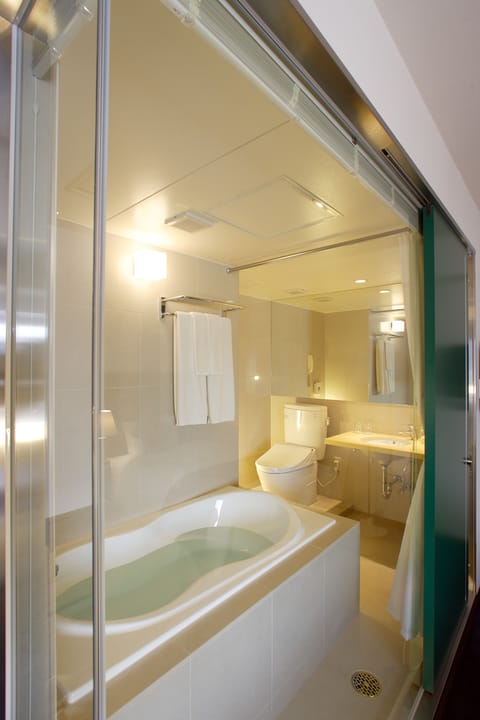 Combined shower/tub, designer toiletries, hair dryer, slippers