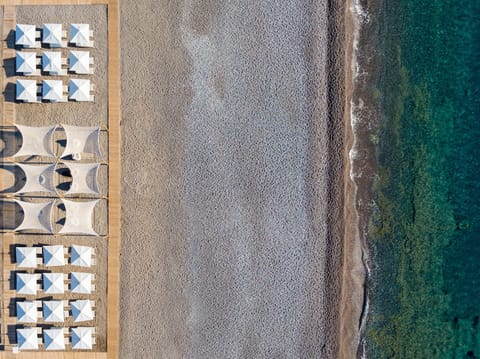 On the beach, black sand, sun loungers, beach umbrellas