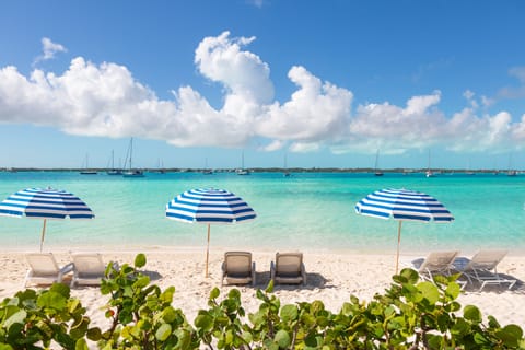 On the beach, white sand, sun loungers, beach umbrellas