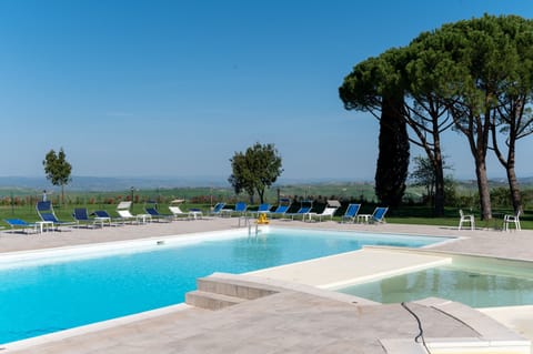 Outdoor pool, a waterfall pool, pool umbrellas, sun loungers