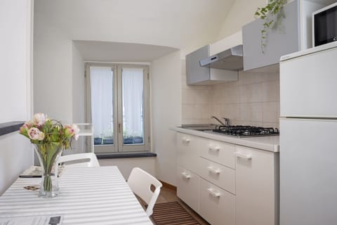 Premium Apartment (Camelia - Via Signorelli 3) | Private kitchen | Stovetop, cookware/dishes/utensils, dining tables