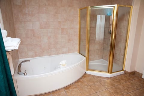 Suite, 1 King Bed, Jetted Tub | Bathroom | Combined shower/tub, designer toiletries, hair dryer, towels