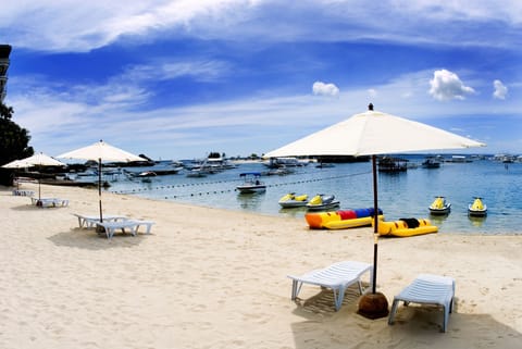 On the beach, white sand, sun loungers, beach towels