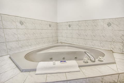 Deluxe Room, 1 King Bed, Non Smoking, Hot Tub | Bathroom | Combined shower/tub, hair dryer, towels, soap