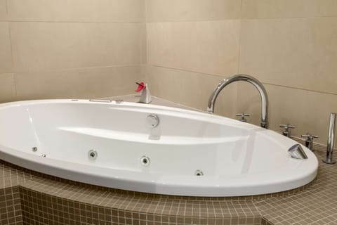 Deep soaking tub, rainfall showerhead, eco-friendly toiletries, towels