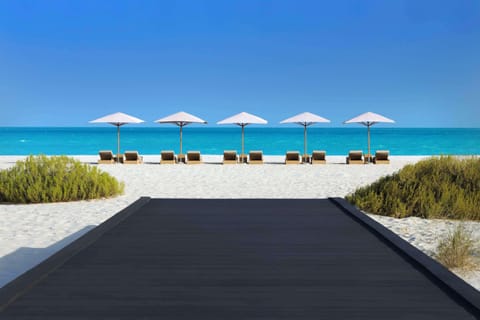 On the beach, white sand, sun loungers, beach umbrellas