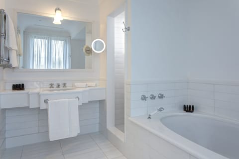 Deep soaking tub, rainfall showerhead, designer toiletries, hair dryer