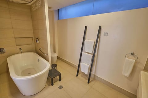 Premiere Deluxe - 1 King Bed | Bathroom | Shower, free toiletries, hair dryer, slippers