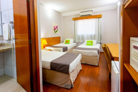 Deluxe Triple Room | Minibar, desk, bed sheets