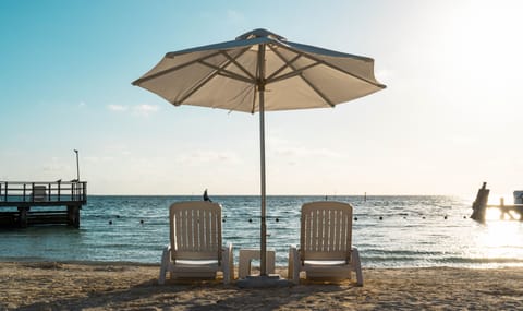 On the beach, white sand, sun loungers, beach umbrellas