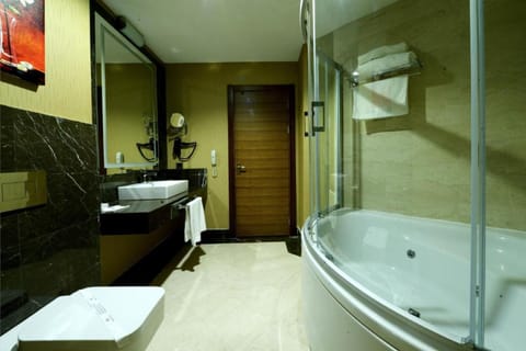 Business Suite, 1 King Bed, Jetted Tub, City View | Bathroom | Hair dryer, towels, soap, shampoo