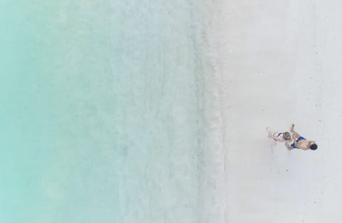 On the beach, white sand, sun loungers, beach umbrellas