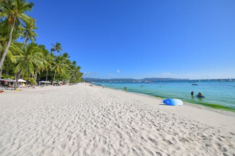 On the beach, white sand, sun loungers, beach towels