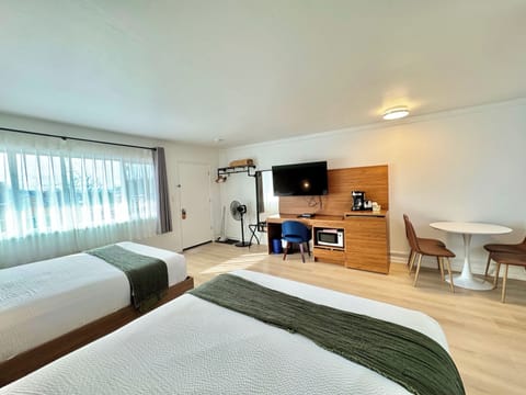 Deluxe Room, 2 Queen Beds, Kitchenette | Living area | 50-inch Smart TV with cable channels, Netflix, streaming services