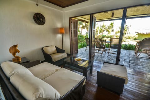 Junior Suite, Beachfront | Living room | 32-inch Smart TV with satellite channels, books