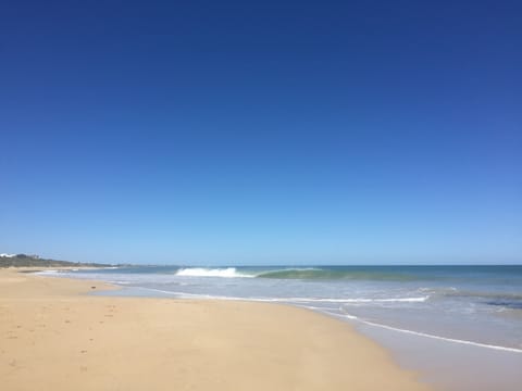 On the beach, white sand, beach umbrellas, beach towels