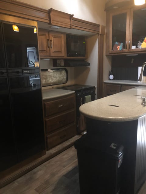 Kitchen includes granite countertops, microwave, stove/oven, and full-size refrigerator/freezer. 