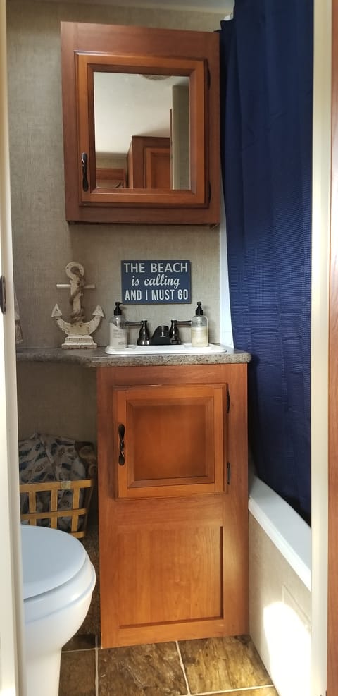 Spacious Bathroom with Tub, Area for Laundry Basket.