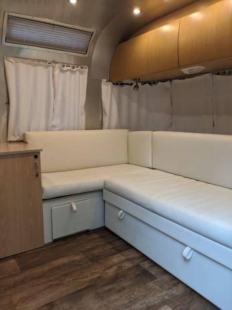 It's got newly upholstered cushions and curtains! The couch pulls out into a full size bed. 