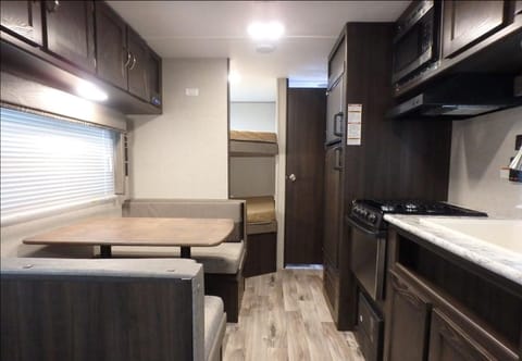 This photo shows the dining table that makes into a small bed about 4 feet long. The two bunk beds are 4 inches narrower than a full size bed. 