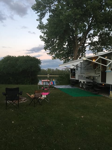 Exterior. Pictured are two entrances (one to the bathroom), outdoor kitchen and awning.