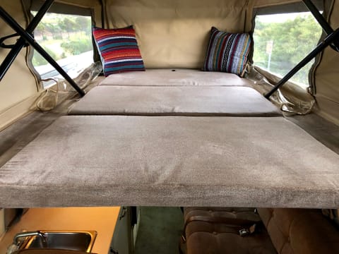 A full-size bed in the pop top.