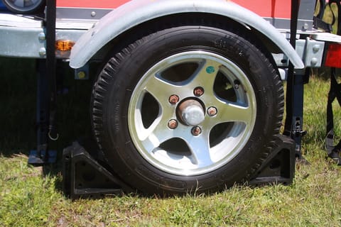 4.80-12 tires with mounted spare on tongue.  Wheel chocks and four "swing down" stabilizer jacks.
