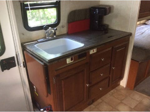 Sink, stove, coffee maker, microwave/convection oven above. Silverware for four, microwave dishes, and towels are provided. Just bring your food and pillow to enjoy you outdoor adventure. 