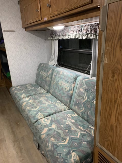 Sofa bed that is opposite the kitchen area.  Easily converts to a comfy bed for 1 or 2.  There are cupboards above the sofa for your grocery items.  As well, there is ample space under the sofa for storage bins.