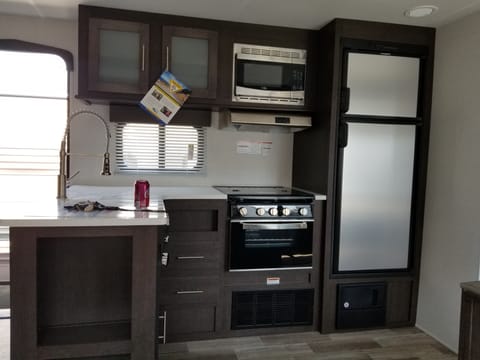 Nearly full kitchen, only missing a dishwasher. Fridge runs automatically based on power source available. Stainless steel amenities, dishes and utensils, cleaning supplies, spices, pots and pans. A little home away from home. 