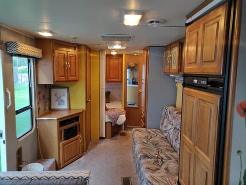 Left Side of Camper when entering. Fold out couch bed, Full Size Bed and Single bunk in back with Bathroom sink, mirror, toilet, and shower.
