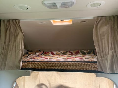 Bed above cab with privacy curtains