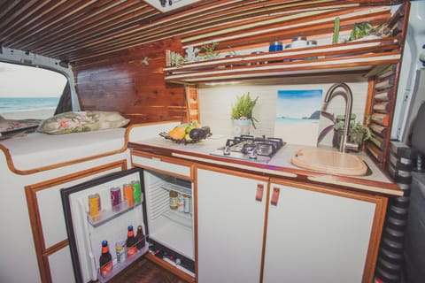 Full kitchen with large sink, two burner propane stove, mini-fridge, and all the cooking utensils you need to make you feel at home