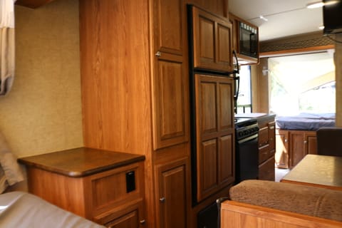 Storage closet and cabinets, bedside table, fridge/freezer, and kitchen. 