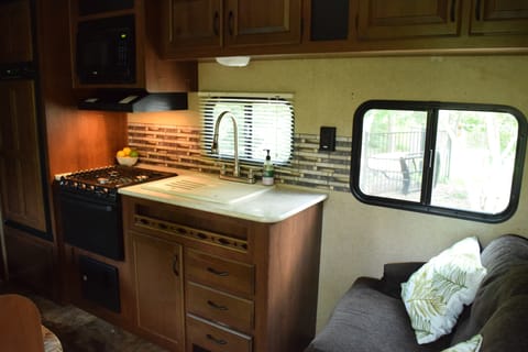 Features kitchen with fridge, freezer, microwave, gas cook top and oven.