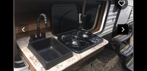 Outdoor kitchen w/ sink,stove and mini fridge.