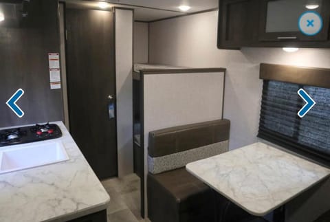 Interior table, kitchen, door to bathroom and bunks in back right