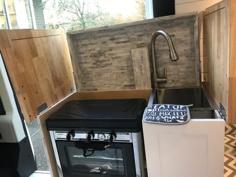 Pop up backsplash, two burner stove, oven and large sink
