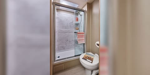 Enjoy natural light. A skylight spreads light over the Greyhawk Prestige shower, which features a decorative surround, detachable showerhead and sliding glass door. You’ll love getting ready in this beautiful bathroom.