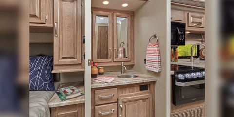 Jack and Jill sink. The Greyhawk Prestige offers the option of a Jack and Jill vanity, between the kitchen and the bedroom. This space boasts a stainless steel sink, a double door medicine cabinet, and Hudson Elm raised panel cabinets.