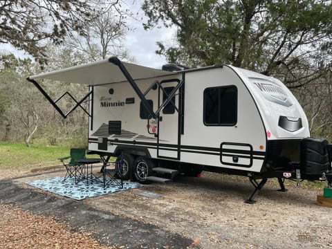 Relax under the awning with included camping chairs, camping table, and rug.