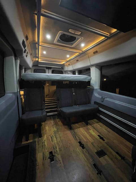 This is Darth Vander ready to sleep! We have lots more customizations coming to make your trip epic. To let you know what you are looking at we have a queen-sized bed up top, seating for 3 passengers (5 including the front seats that aren’t pictured), beautiful wood grain style flooring, and just peeking out between the seats is our gear slide “garage” which has room for storage or to sleep another 1-2 people. Oh, and don’t forget the Espar heater that is under the seat that is keeping me warm taking these photos while it’s below freezing outside.