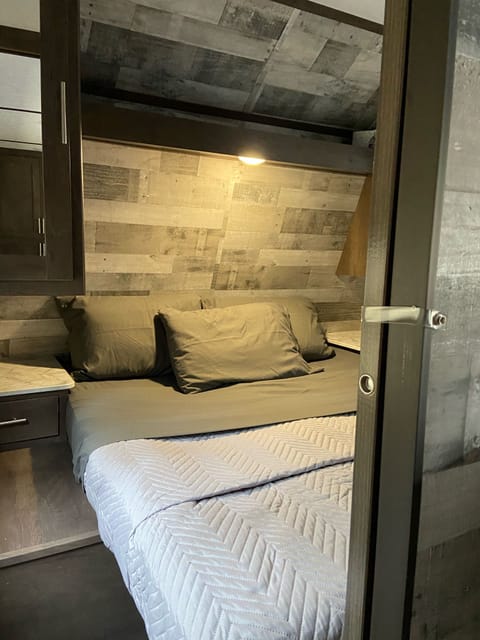 Sliding doors create a private master bedroom with queen bed and plenty of bedside storage. USB chargers built in.