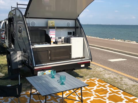 The teardrop has a fantastic outdoor kitchen! Pictured and included in the rental are 2 camping chairs, a collapsible table for 2 and an outdoor rug.