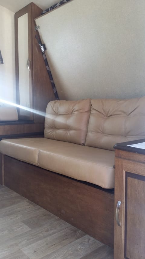 Enter into living room couch, with Murphy bed above.