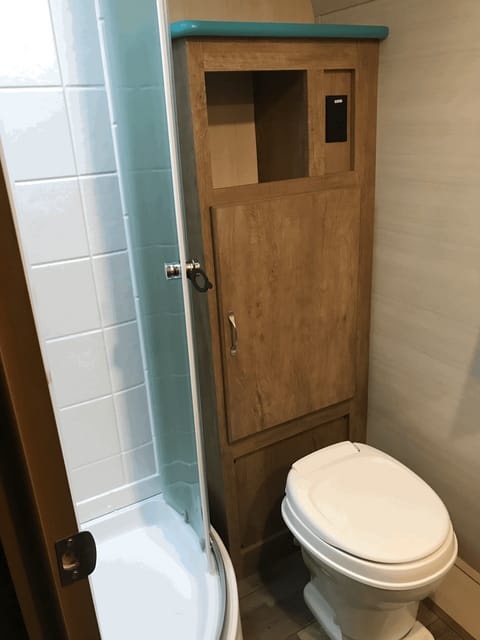 Large shower with sliding doors. Toilet and lots of storage.