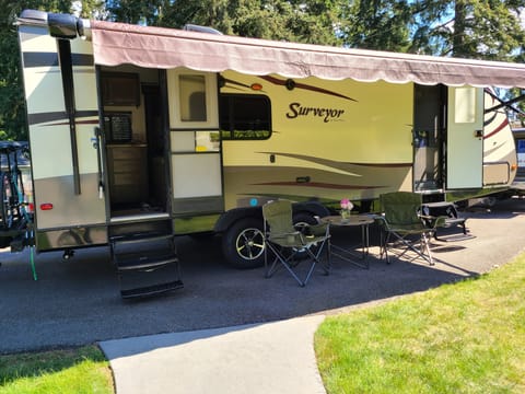 Large adjustable awning with lights covers both entrances into trailer. Entrance into kitchen in back and master bed in front