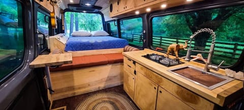 Inside the luxury Sprinter.  Queen Bed, plenty of storage and kitchen with a propane stove.  