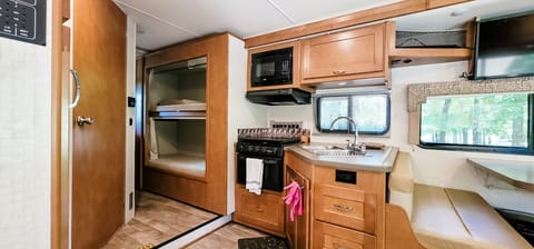This kitchen has a two compartment sink, 3 burner stove, oven, and microwave.  Comes loaded with cookware, utensils, plates glasses and silverware.